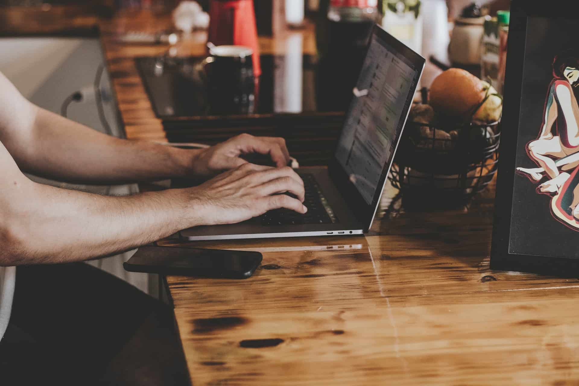 Hands typing on a laptop